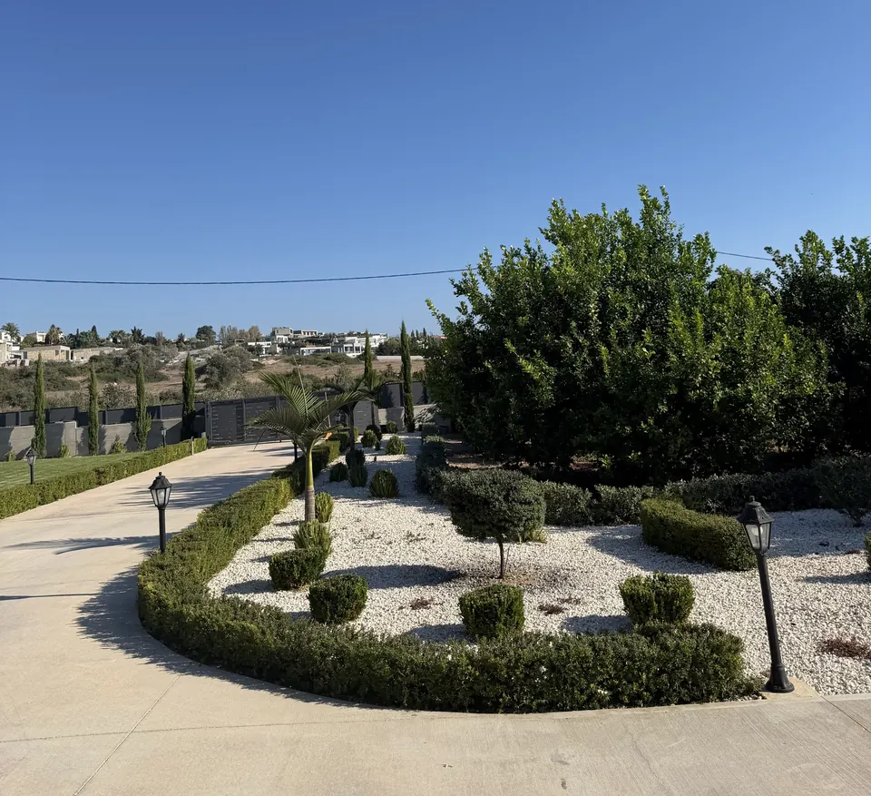 Curved hedge, topiary and white stone along a driveway, a garden completed by Green Plot
